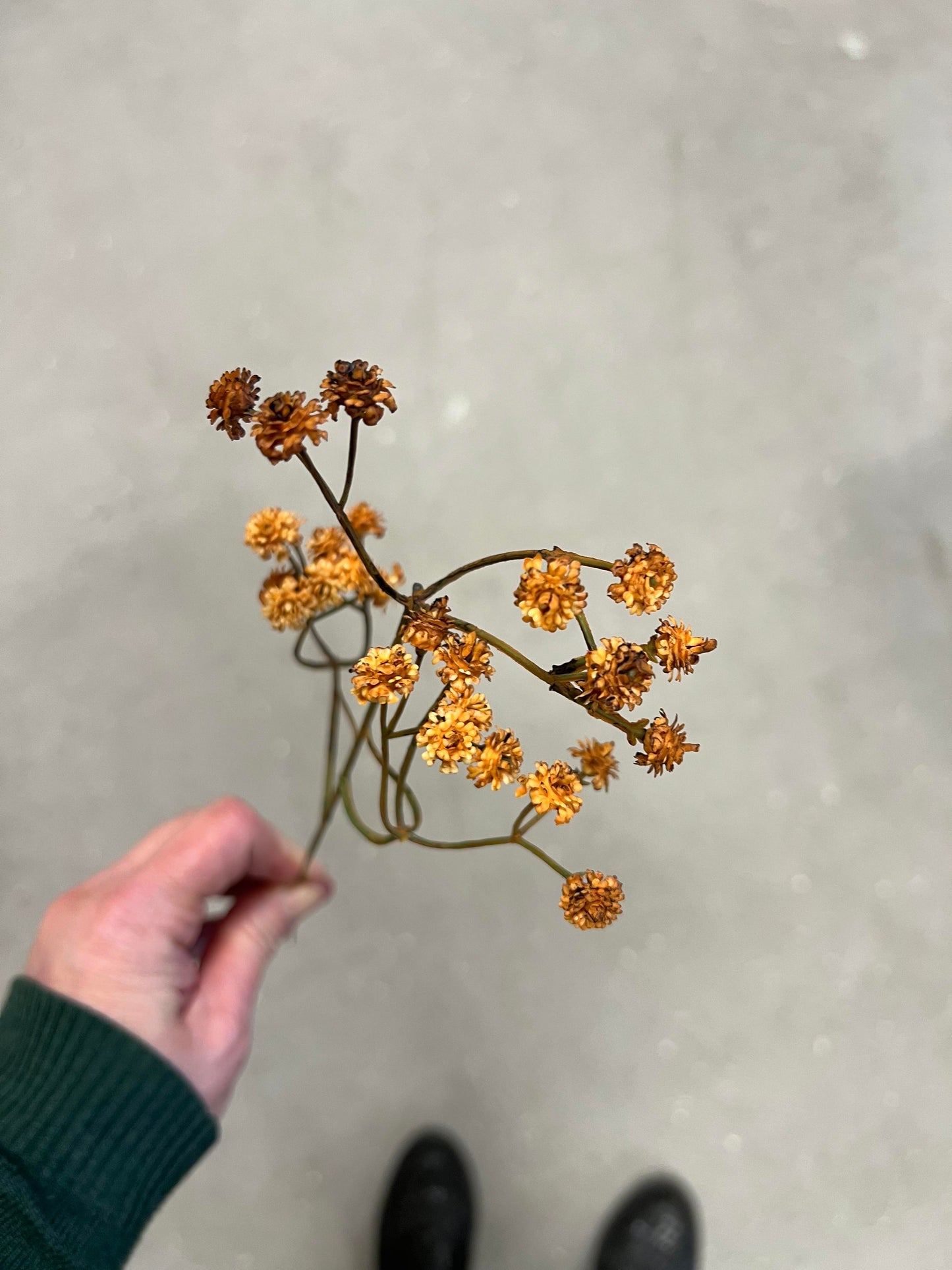 Kunstig blomsterstilk med små blomster i brun og rust