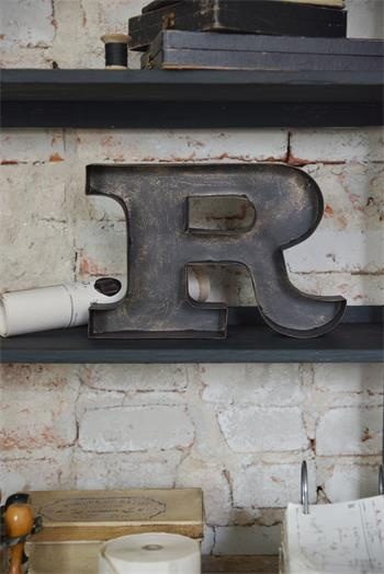 R - tegn i brunt metal